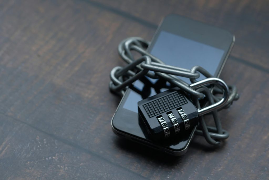 Close-up of a smartphone wrapped in a chain with a padlock, symbolizing strong security. for privacy policy